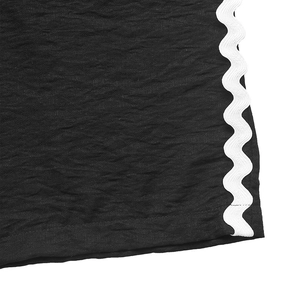Détail macro de la texture plissée noire avec bordure décorative blanche en zigzag