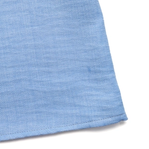 Detail view of light blue twill fabric hem with precise stitching and fine texture on skirt