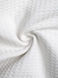 Close-up of the white waffle weave texture and breathable fabric detail on summer shorts