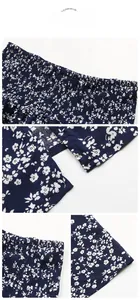 Detailed view of elastic smocking waist and floral print on dark blue midi skirt