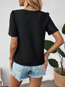 Close-up of black textured knit T-shirt back view showing bow tie and pleated details