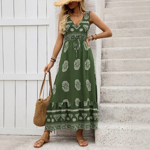 Detail of dark green boho dress with white prints, drawstring waist, and ruffled hem
