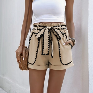 Women's khaki high-waisted paperbag shorts with black scalloped trim and bow belt