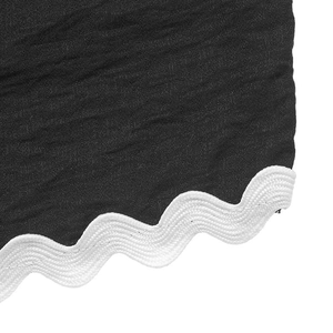 Vue détaillée du tissu gaufré noir avec bordure festonnée blanche et finitions soignées
