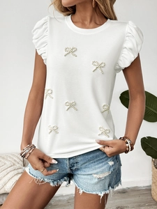 Detail of beaded bow accents and puffed sleeves on this white summer casual t-shirt