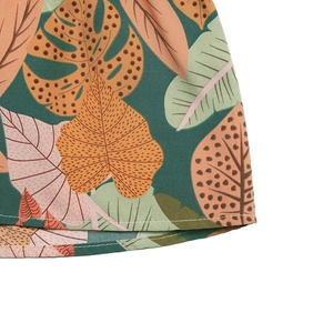 Detailed macro view of tropical leaf print on green woven fabric with clean stitching