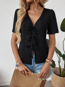Detail of black V-neck t-shirt with textured fabric and front ribbon tie closures