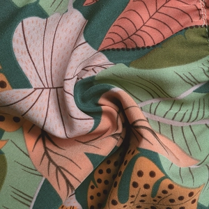 Macro shot of tropical leaf print fabric showing woven texture and botanical patterns
