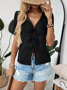 Close-up of black V-neck textured knit T-shirt featuring three delicate front bow ties