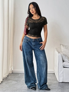Close-up of black lace patchwork T-shirt paired with retro wide-leg denim jeans