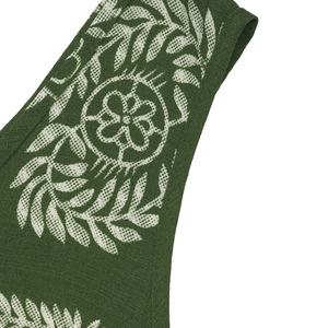 Detailed view of the dark green fabric featuring ethnic white leaf and floral knit patterns