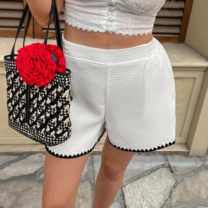 Women's white waffle knit shorts with elastic waist and black wavy contrast trim