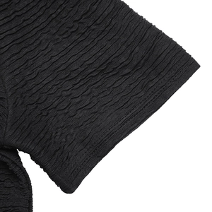 Detailed macro view of black short sleeve featuring unique textured crinkle fabric