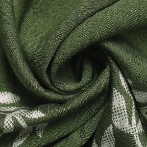 Detailed macro view of green linen fabric texture with white leaf print on summer dress