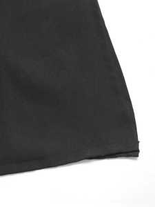 Dettaglio dell'orlo dell'abito nero con ricami etnici e texture in tessuto di alta qualità