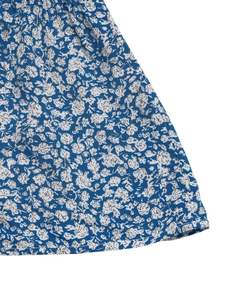 Detail of blue and white floral skirt showing fabric texture and neat hemline stitching