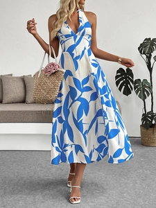 Détail de l'imprimé feuilles bleues sur robe longue dos nu avec un décolleté plongeant