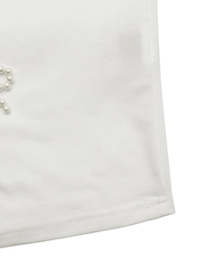 Detail shot of white fabric texture featuring elegant beaded pearl embellishments