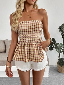 Detailed view of plaid peplum tube top paired with distressed white denim shorts