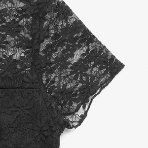 Close-up of elegant black floral lace texture and sheer crochet patterns on the women's top