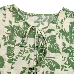Detail of floral sleeveless shirt neck with pleated texture and adjustable tie strap