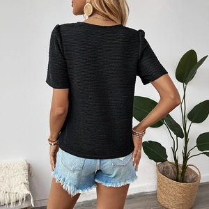 Back view of a black textured knit T-shirt for women styled with denim shorts