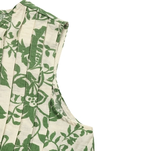 Close-up of pleated texture and green floral print on sleeveless cotton-linen blouse
