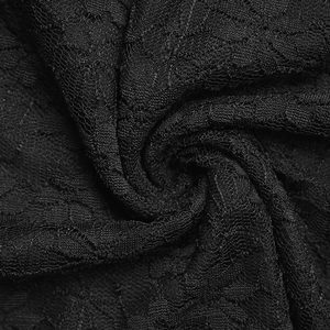 Close-up of the intricate floral lace embroidery and sheer mesh texture on black fabric