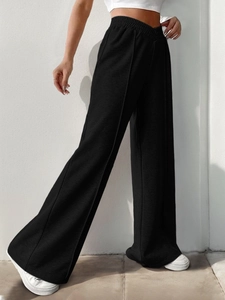 Close-up of black high-waisted wide-leg trousers with front seam details and soft texture