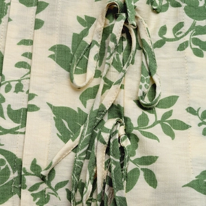 Macro detail of summer floral print sleeveless shirt with pleated texture and ties