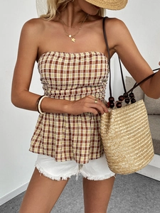 Detail of checkered peplum tube top with straw bag for a chic summer resort look