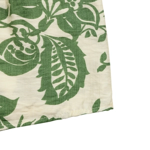 Close-up of floral print fabric showing detailed green leaf patterns and neat stitching