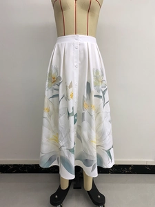 Detalle del estampado floral de lirios y botones frontales en la falda blanca