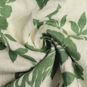 Close-up of green leaf print on beige pleated fabric with premium twill texture