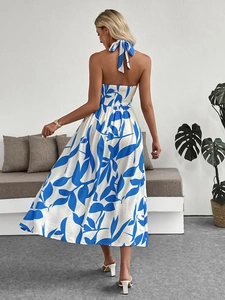 Vue de dos d'une robe dos nu blanche avec imprimés tropicaux bleus et design ouvert