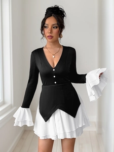 Detailed view of elegant V-neckline with white buttons and ruffled layered cuffs