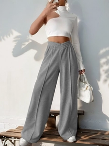 Detail shot of grey wide-leg lounge pants with high V-waist and vertical pleats