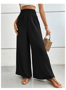 Detail of high waisted black wide leg pants featuring an elastic smocked waist texture