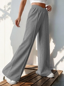 Detail of high waisted grey wide leg sweatpants with V-shaped waistband and front seam line