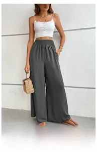 Detailed texture of high-waist pleated elastic waistband on dark grey wide-leg trousers