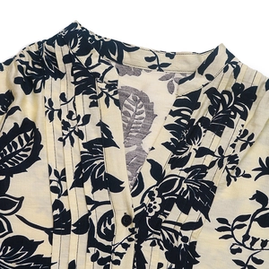 Detail of vintage floral print shirt with pleated stand collar and elegant button design