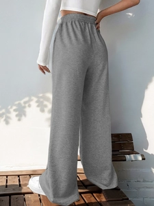 Rear view of grey wide leg trousers showing elastic high waist and raw hem detail