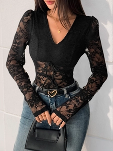 Détail du body noir en dentelle à manches longues avec décolleté en V et lien à la taille