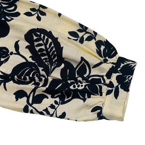 Detail of vintage floral pattern on cream long sleeves with pleated cuff craftsmanship