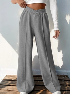 Detail of grey wide-leg sweatpants featuring a high-waisted V-shaped crossover design