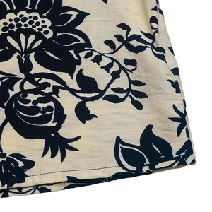 Detail of vintage navy blue floral print on ivory linen fabric with neat stitching