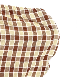 Macro shot of brown and beige plaid fabric with detailed elastic gathering texture