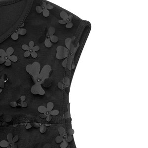 Détail de la combinaison noire montrant des appliques florales 3D et du tulle mesh