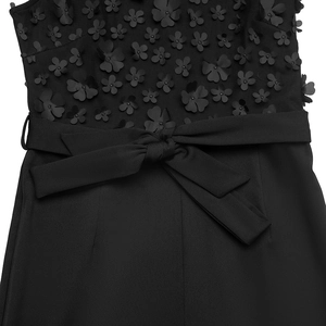 Détails d'appliqués floraux 3D et ceinture à nouer sur une combinaison noire sans manches