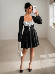 Detail of long sleeve dress with contrast polka dot bodice and vertical stripes